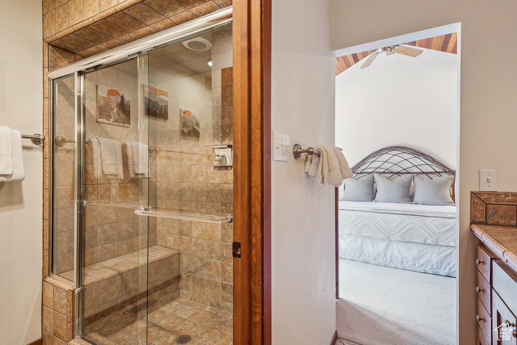 Ensuite bathroom with a shower stall, vanity, and ceiling fan