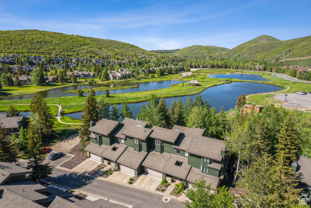 Aerial view of property's location with a water and mountain view and nearby suburban area