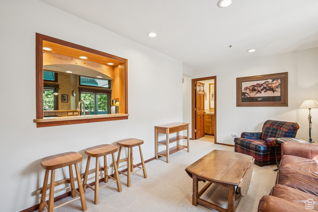 Carpeted living area with recessed lighting and baseboards