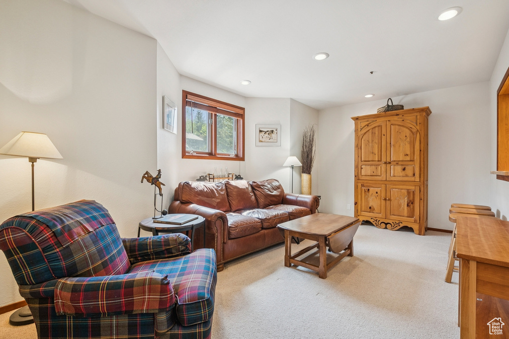 Living area featuring light colored carpet and recessed lighting