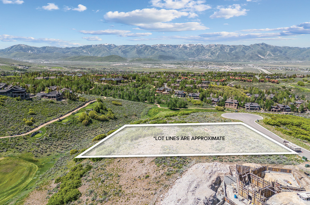 Aerial view of residential area with property boundaries highlighted and mountains