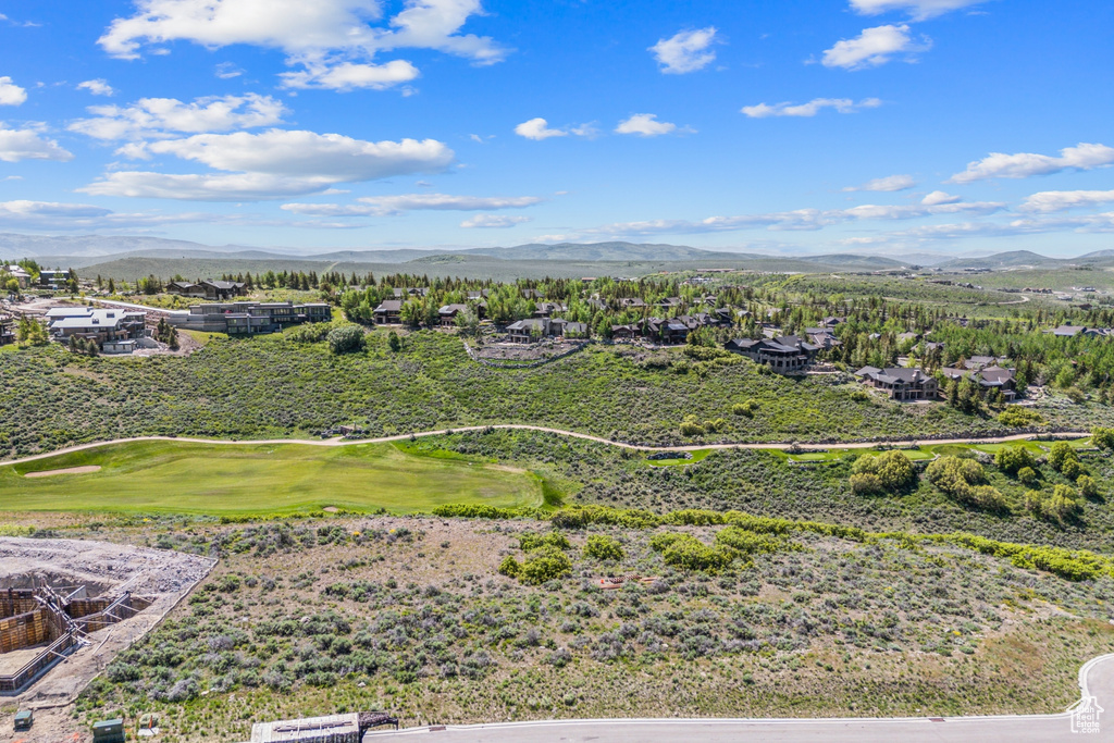 Aerial perspective of suburban area with a mountainous background and a local golf course