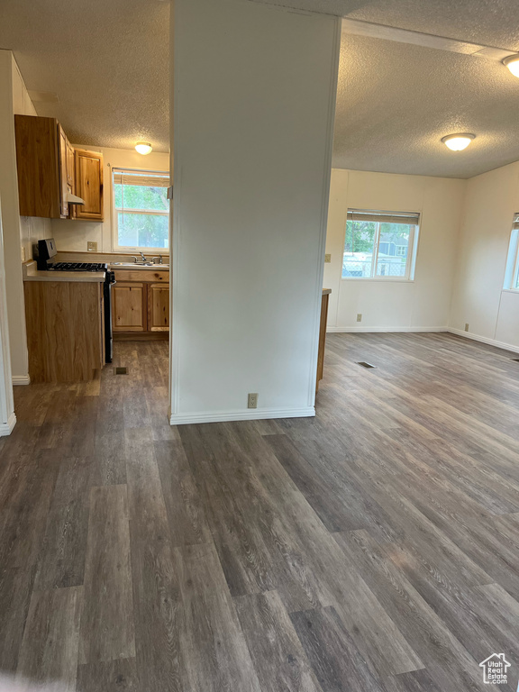 Kitchen featuring range, open floor plan, a textured ceiling, healthy amount of natural light, and brown cabinetry