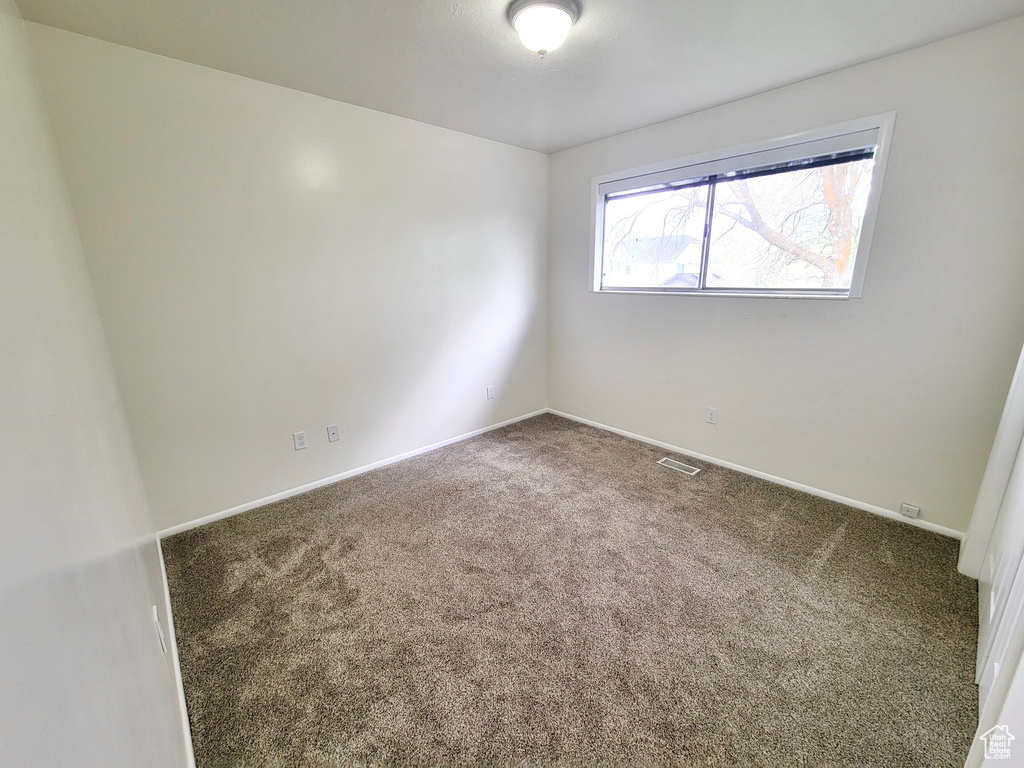 Carpeted empty room featuring baseboards