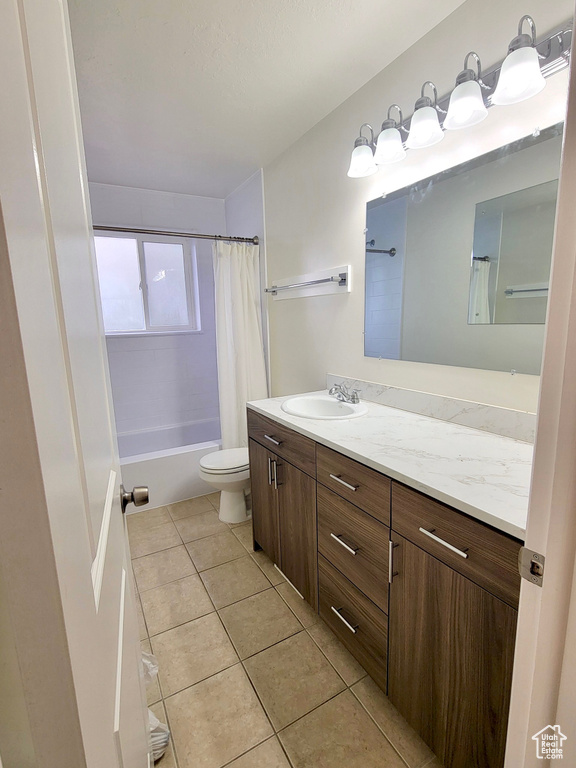 Bathroom featuring vanity, tile patterned flooring, toilet, and shower / tub combo