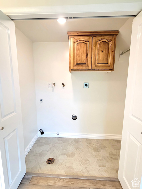 Laundry room featuring hookup for an electric dryer, hookup for a gas dryer, baseboards, and cabinet space