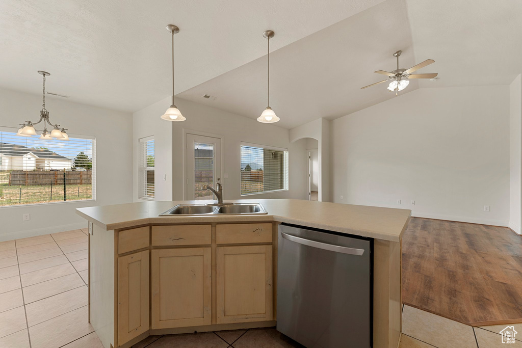 Kitchen with dishwasher, a sink, light countertops, arched walkways, and light tile patterned floors