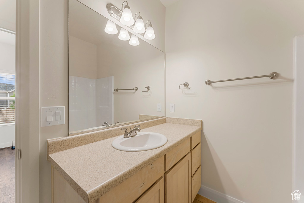 Bathroom featuring vanity, baseboards, and a shower