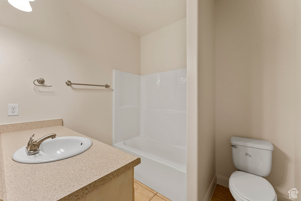 Bathroom featuring vanity, tile patterned flooring, toilet, and bathtub / shower combination