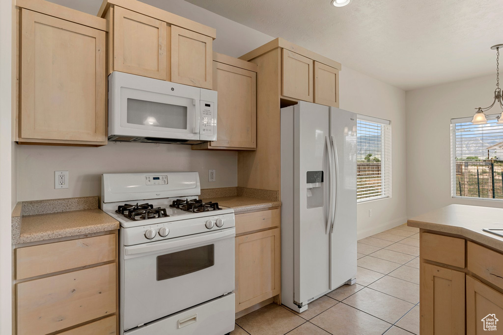 Kitchen featuring white appliances and light brown cabinets