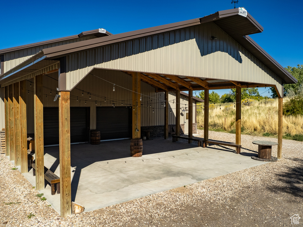 View of vehicle parking featuring a carport, concrete driveway, and a garage