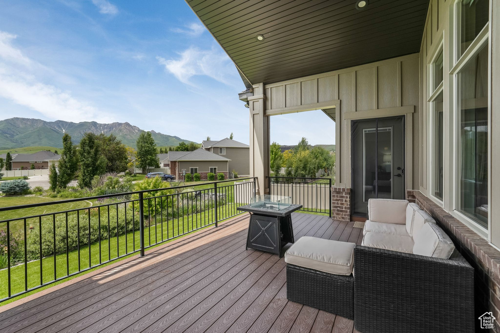 Wooden deck featuring a mountain view and an outdoor fire pit