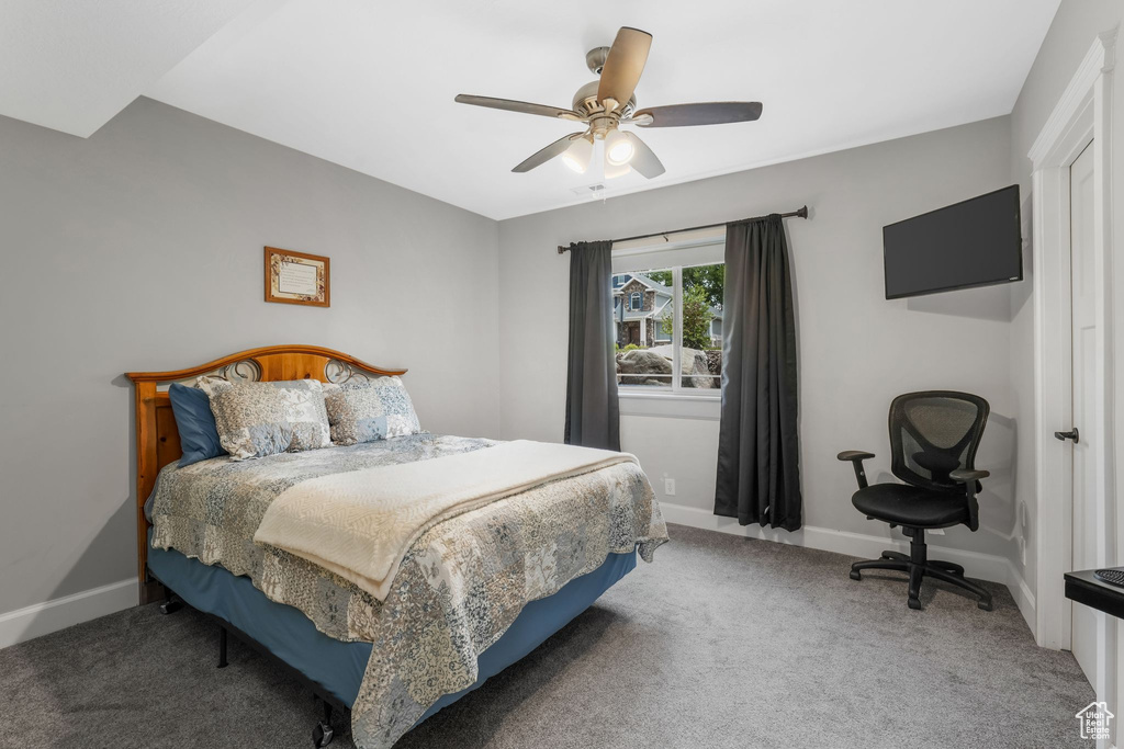 Bedroom with carpet flooring, baseboards, and ceiling fan
