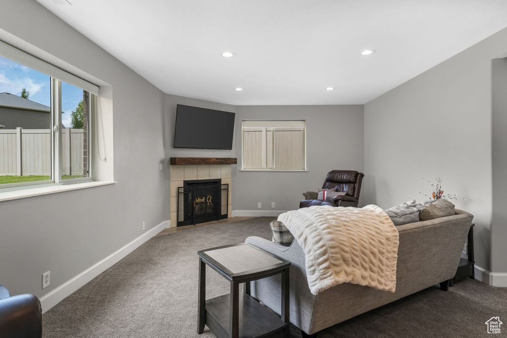 Carpeted living area with baseboards, a tile fireplace, and recessed lighting
