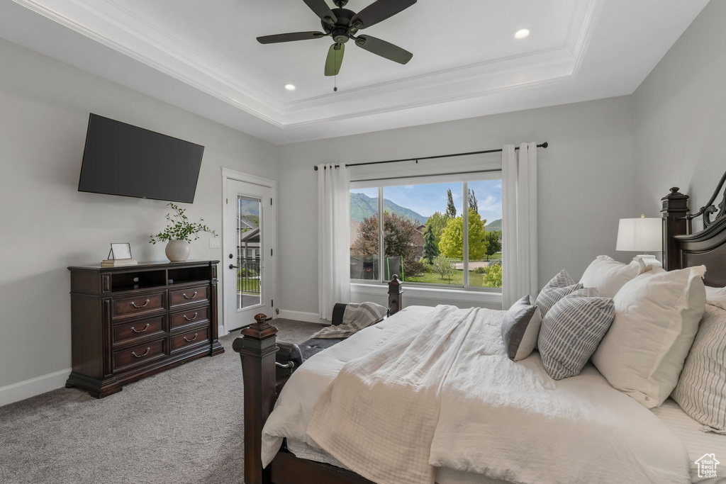 Bedroom with a tray ceiling, baseboards, access to exterior, carpet flooring, and recessed lighting