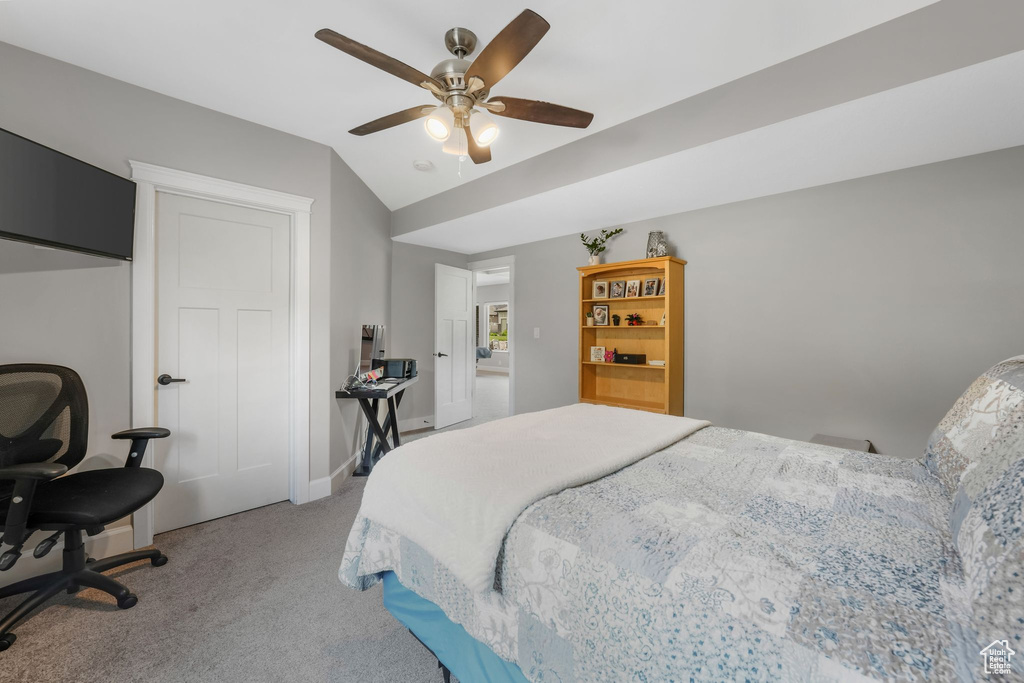 Carpeted bedroom with lofted ceiling, ceiling fan, and baseboards