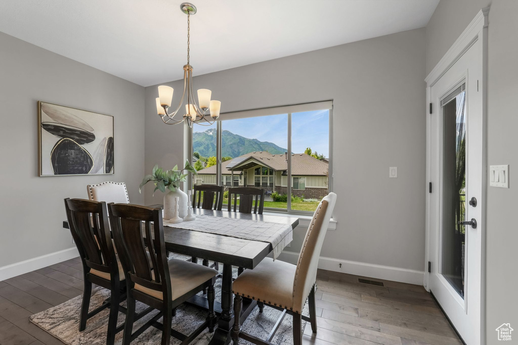 Dining room with a chandelier, baseboards, wood finished floors, and a mountain view