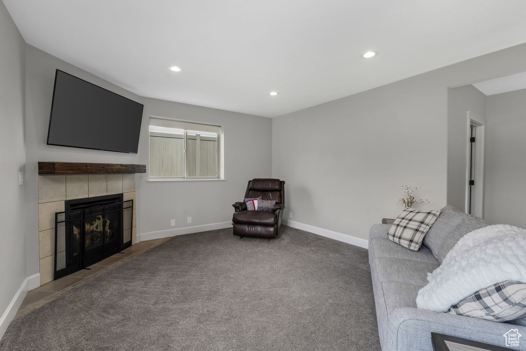 Carpeted living area featuring a tile fireplace, recessed lighting, and baseboards