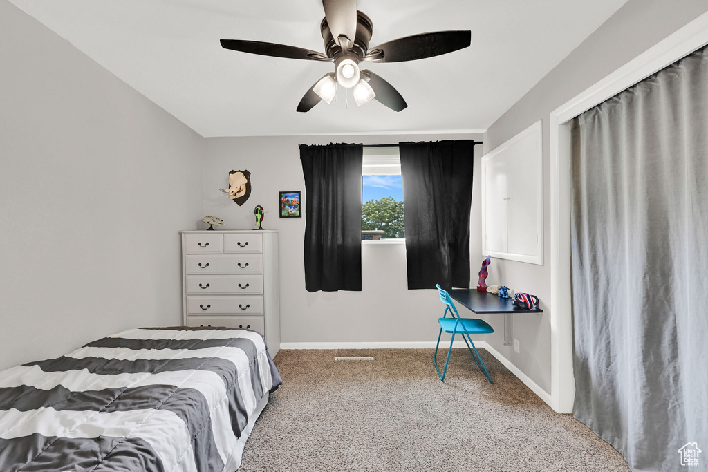 Bedroom with carpet flooring, baseboards, and a ceiling fan