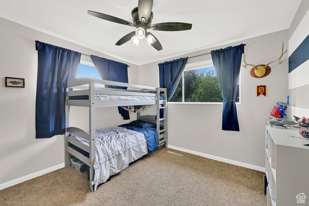 Carpeted bedroom with baseboards and a ceiling fan