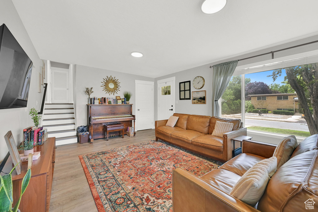 Living area featuring light wood-style floors, stairway, and recessed lighting