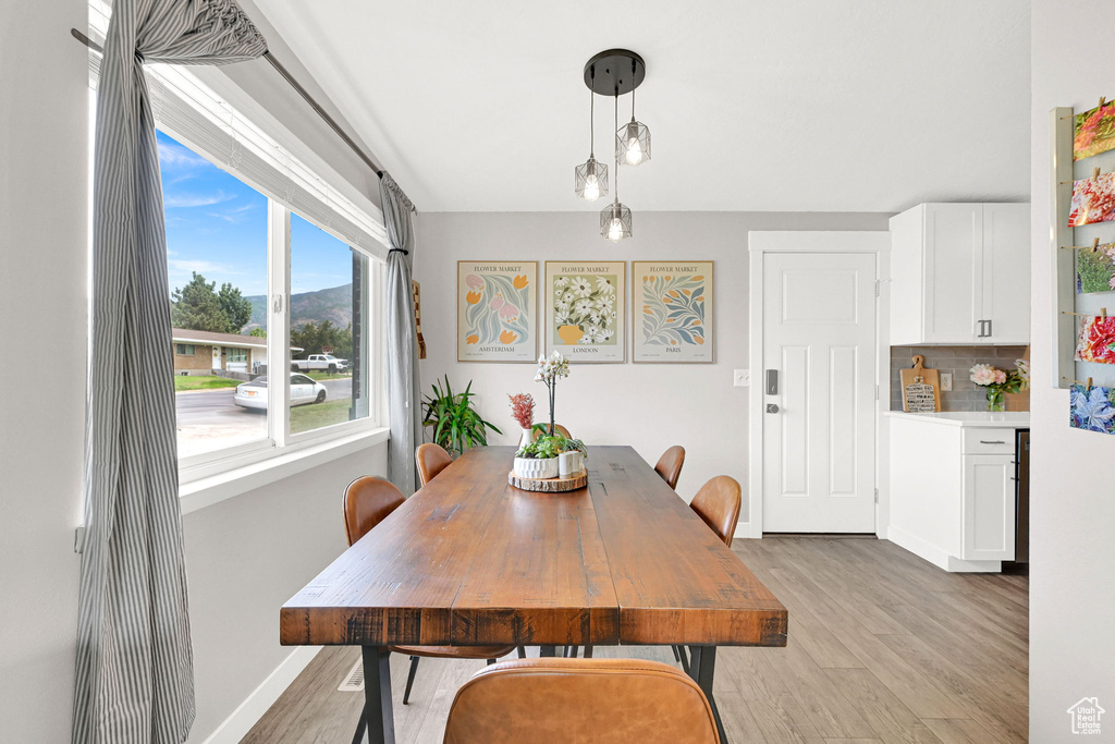 Dining space with light wood-style flooring and baseboards