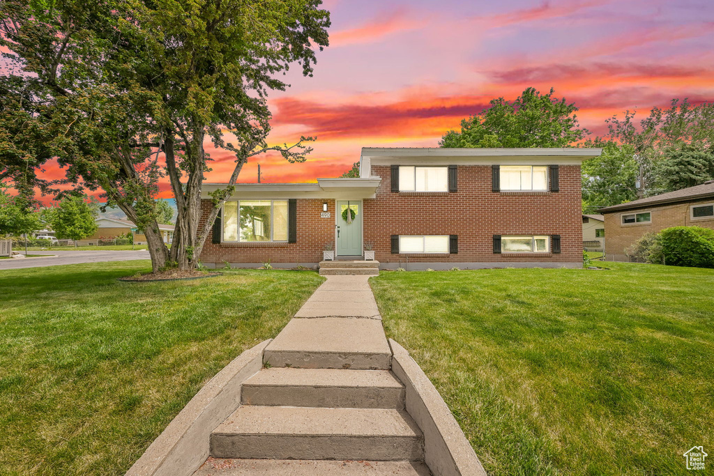 Split level home featuring brick siding and a lawn
