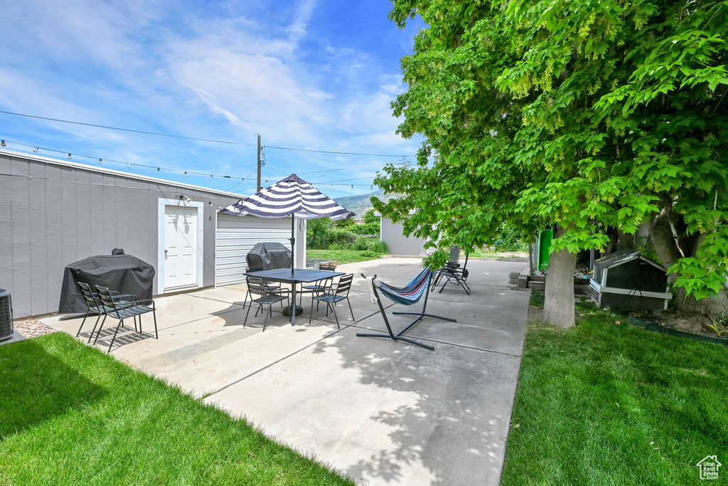 View of patio featuring grilling area, central air condition unit, and outdoor dining space