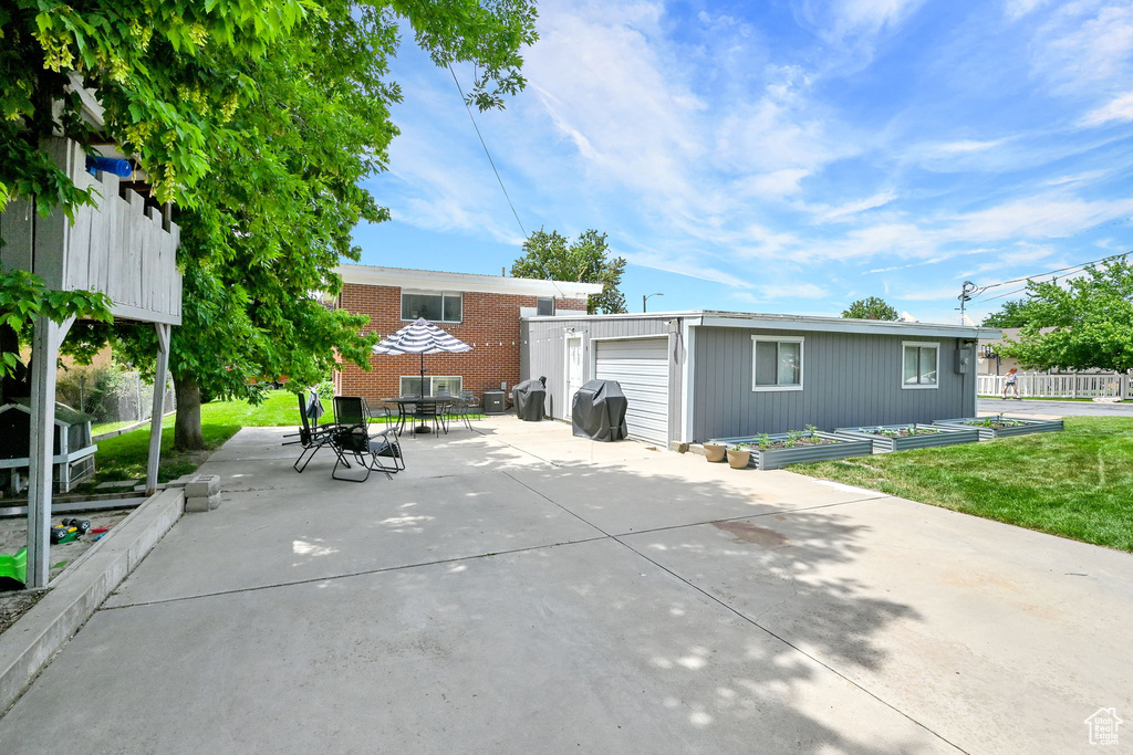 Rear view of house with an outbuilding and a patio