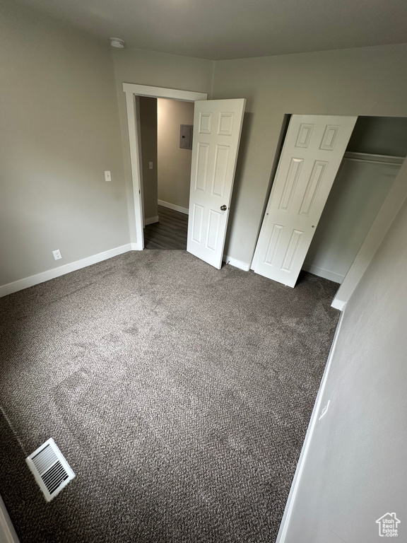 Unfurnished bedroom with carpet flooring, baseboards, and a closet