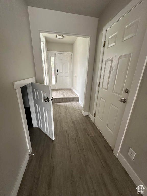 Hall with dark wood-style flooring and baseboards
