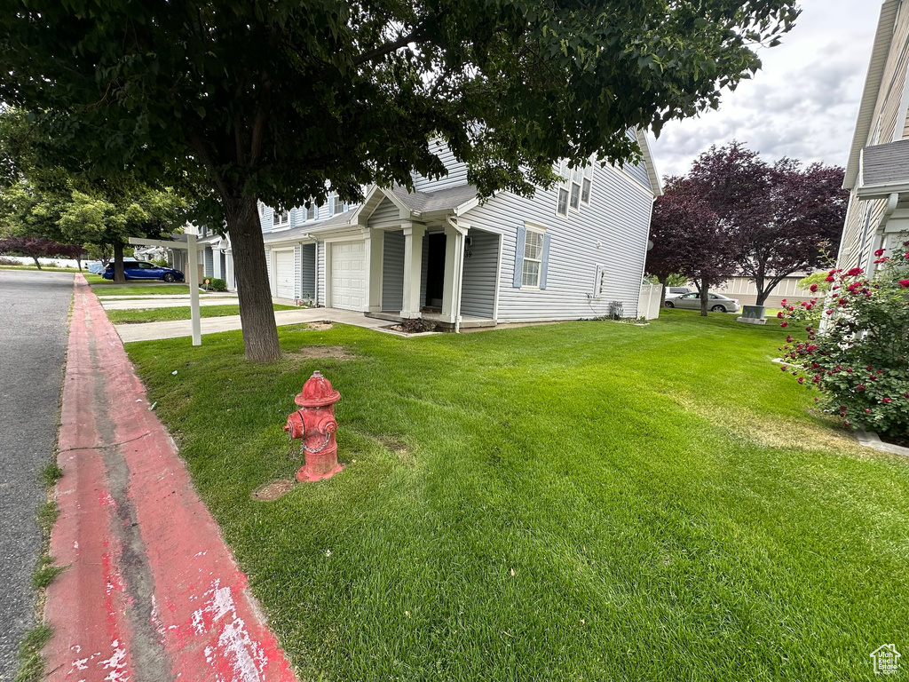 View of front of home featuring an attached garage, a front lawn, and concrete driveway