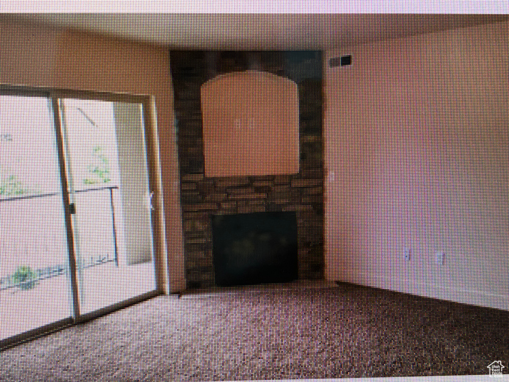Unfurnished living room featuring a fireplace and carpet flooring