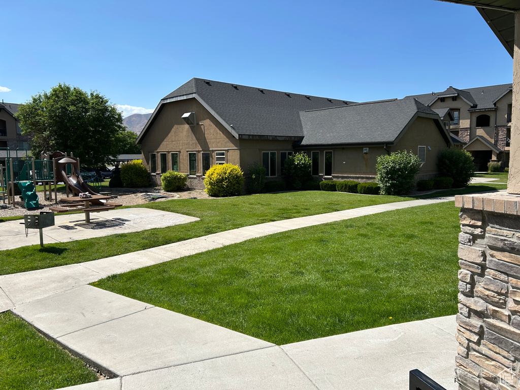 View of front of house featuring a playground and a front lawn