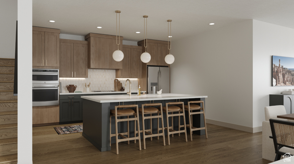 Kitchen with stainless steel appliances, wood finished floors, tasteful backsplash, light countertops, and a breakfast bar
