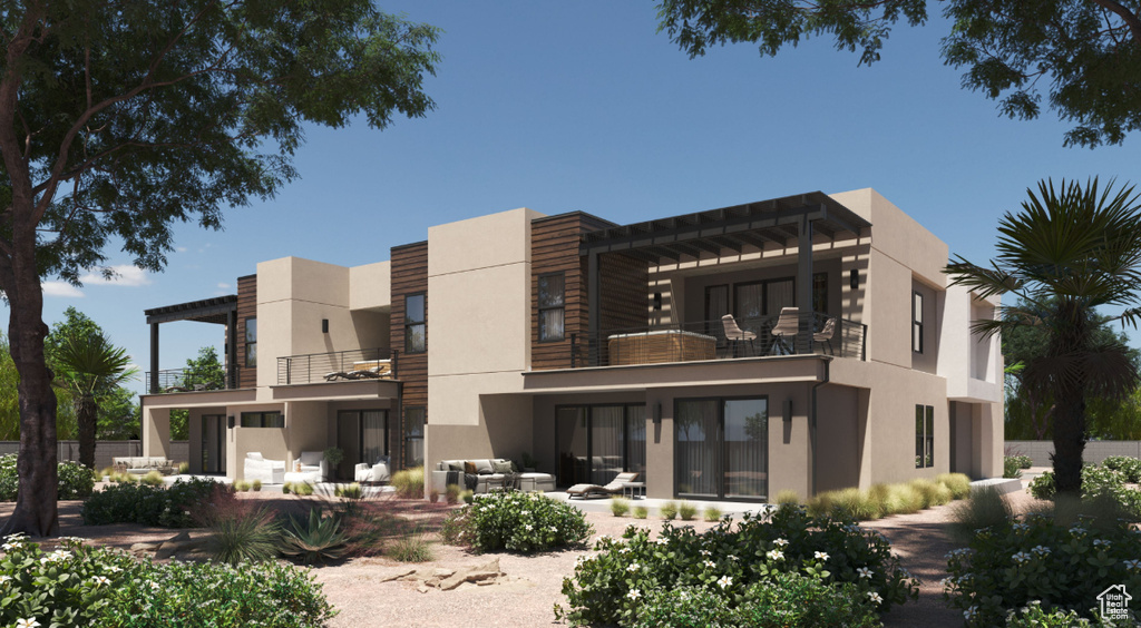 Back of house featuring a balcony, stucco siding, and a patio