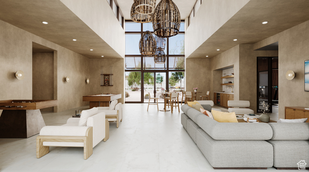 Living area featuring a towering ceiling, a chandelier, and recessed lighting