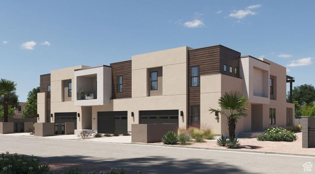 View of front of house with stucco siding and a garage