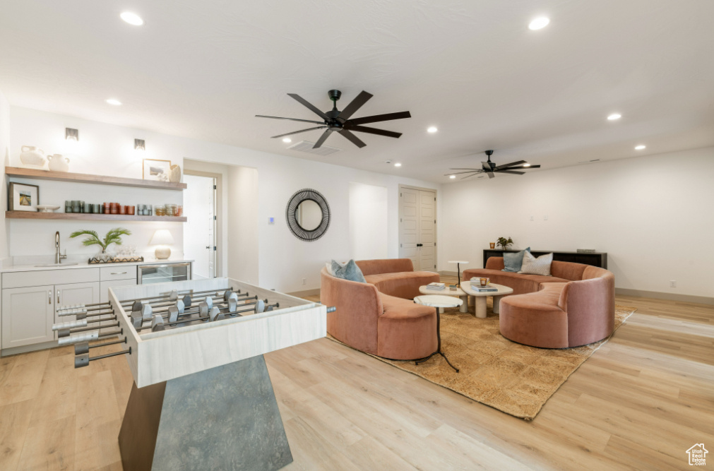 Living area featuring ceiling fan, recessed lighting, light wood-type flooring, and beverage cooler