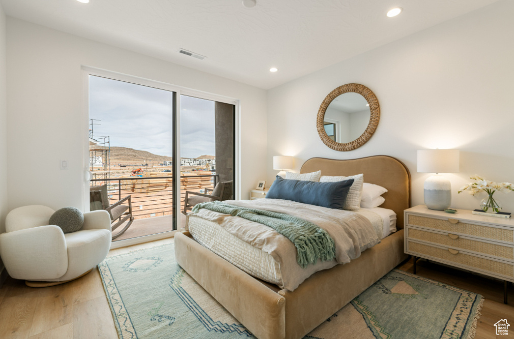 Bedroom with access to outside, wood finished floors, and recessed lighting