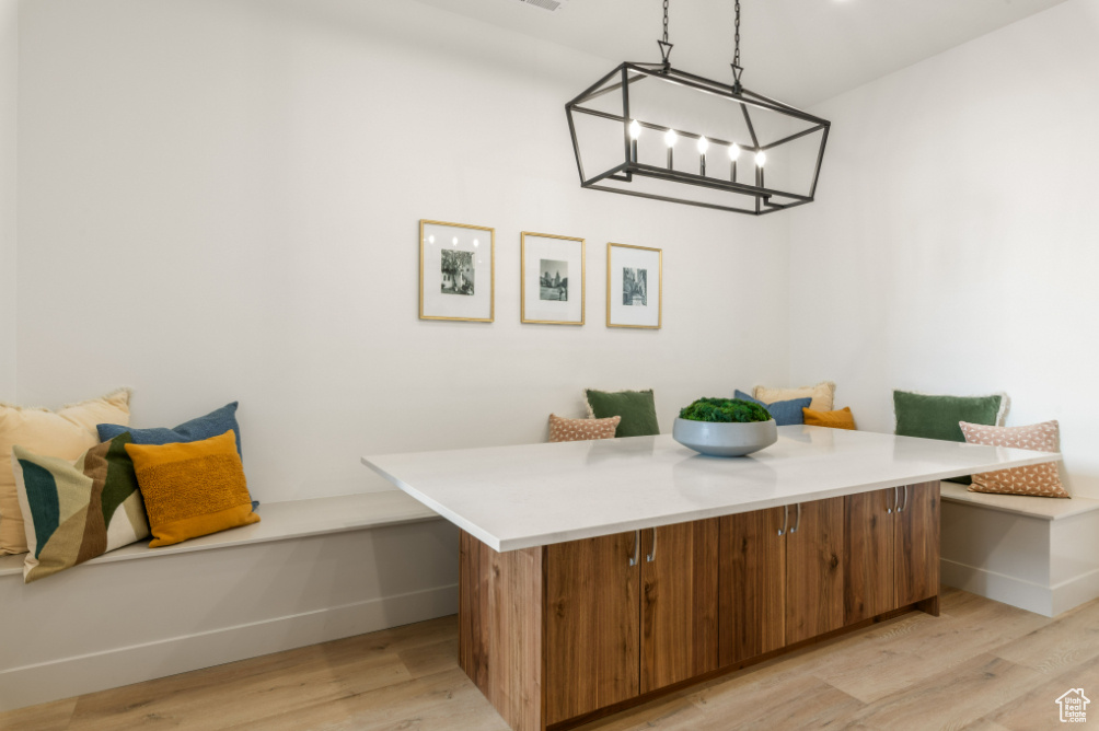 Dining area with light wood-type flooring, baseboards, and a chandelier