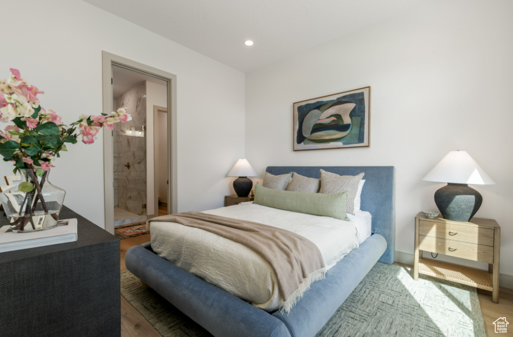 Bedroom featuring wood finished floors, recessed lighting, and ensuite bath