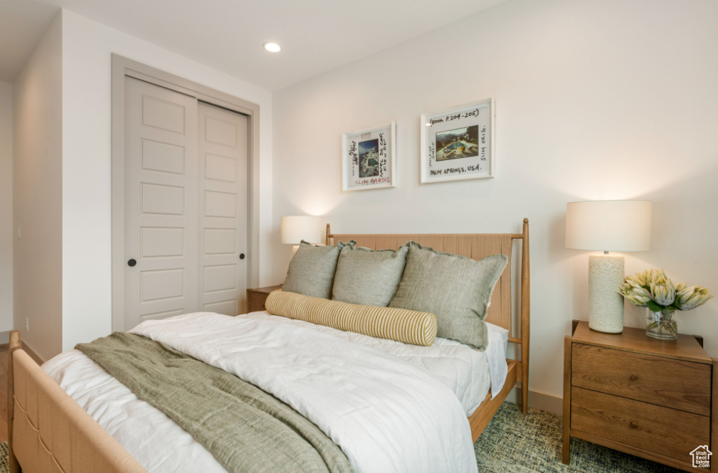Bedroom with a closet, recessed lighting, and carpet floors