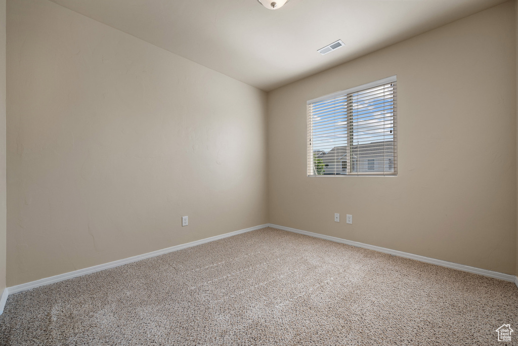 Carpeted empty room featuring baseboards