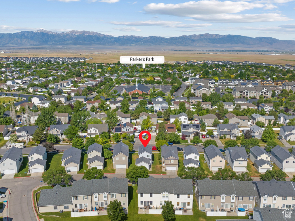 Aerial view of property and surrounding area with a mountain backdrop and nearby suburban area