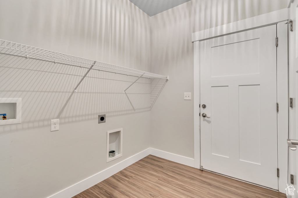 Laundry area with electric dryer hookup, baseboards, washer hookup, and wood finished floors