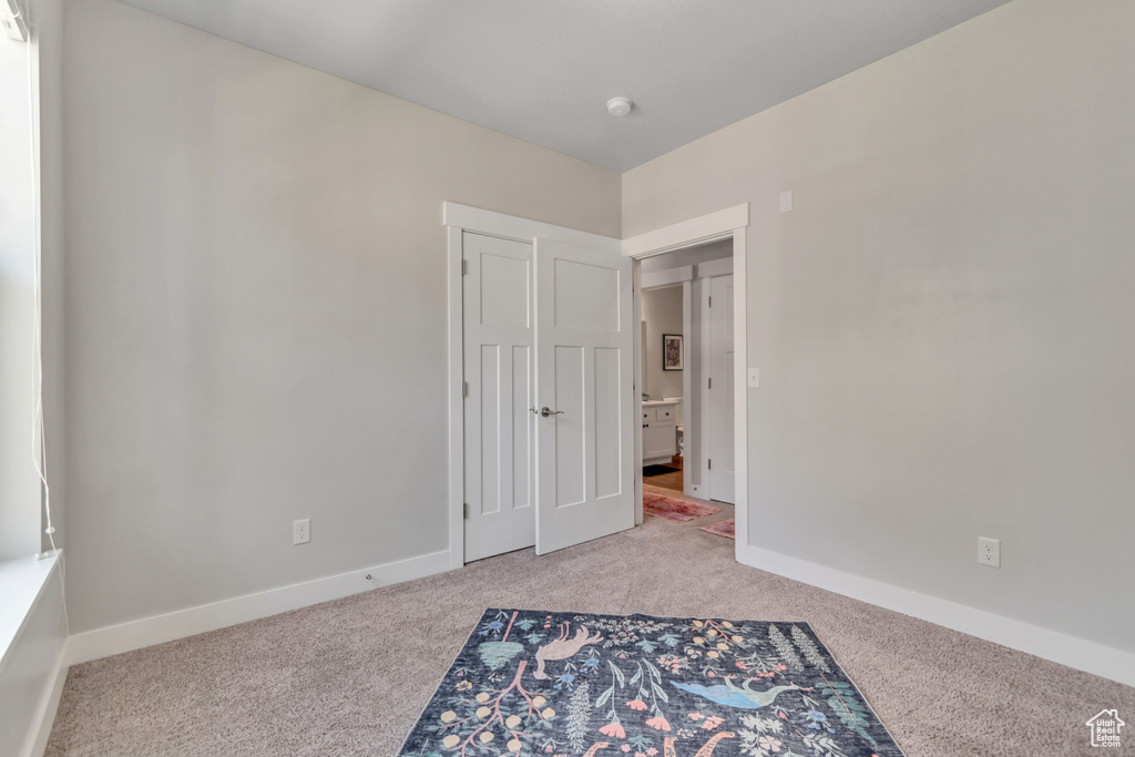 Unfurnished bedroom featuring carpet floors and baseboards