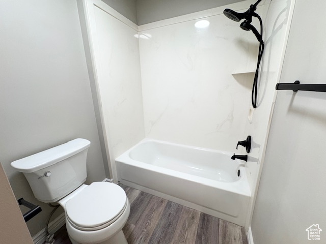 Full bathroom with wood finished floors, toilet, and bathtub / shower combination