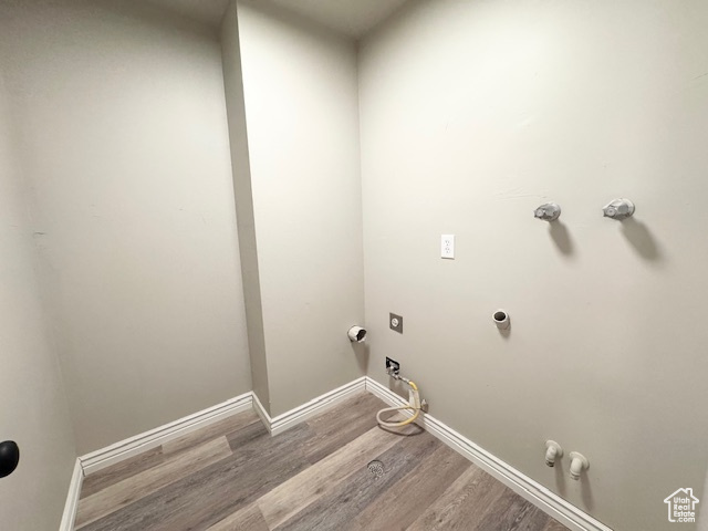 Washroom featuring gas dryer hookup, wood finished floors, and baseboards