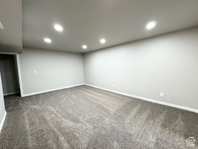 Spare room featuring recessed lighting, dark carpet, and baseboards